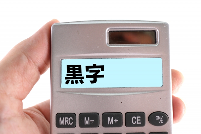 電卓を持つ手 電卓に表示された黒字