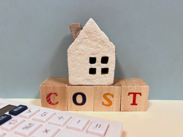 COSTと書かれた木製ブロック 家の模型 電卓
