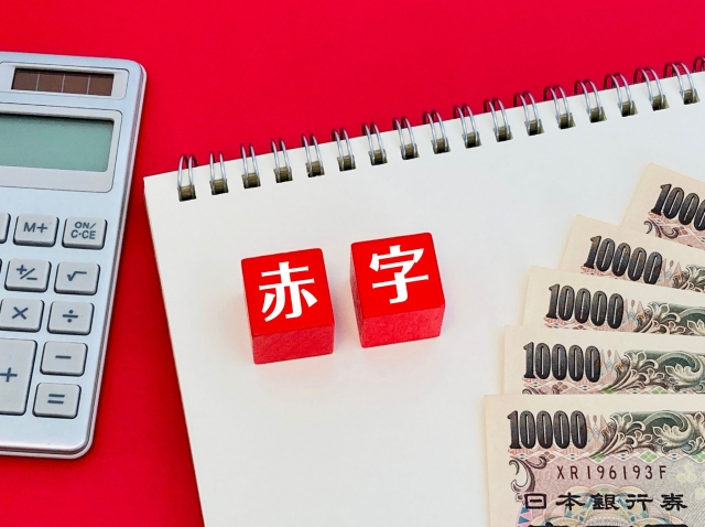 赤字 1万円札 電卓とノート