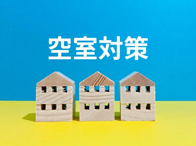 空室対策 3軒の木のアパートの模型 青と黄色の背景