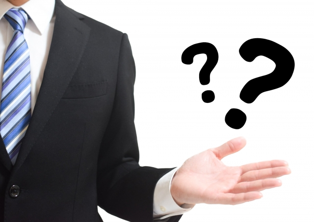 ビジネスマン 手の平の上に2つのクエスチョンマーク