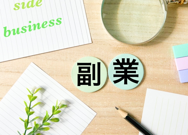 副業と書かれたマルイカード 虫眼鏡 数枚のノートの切れ端