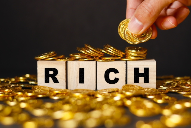 RICH 金色のコイン コインを摘まむ手